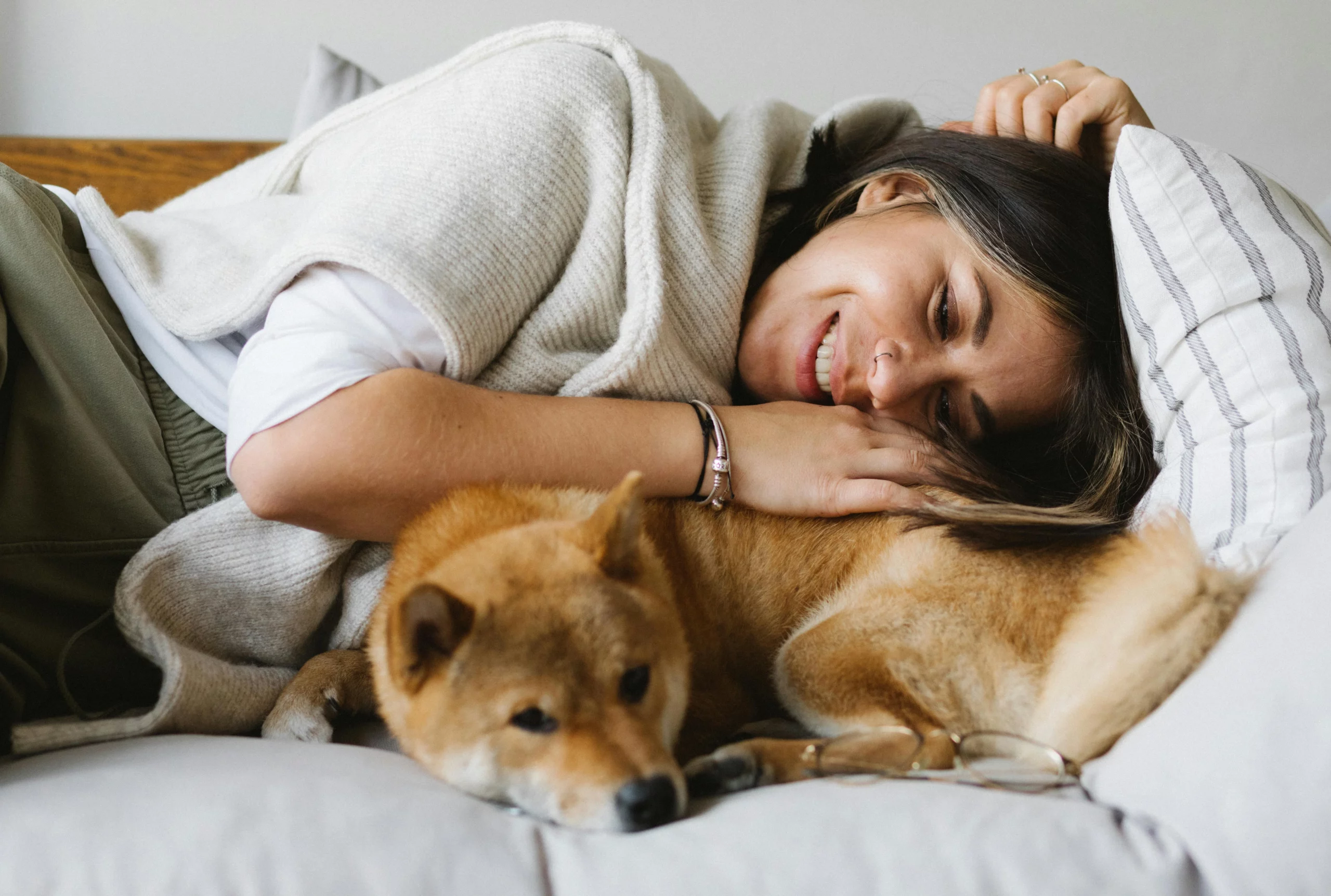 Happy owner and dog cuddled on couch